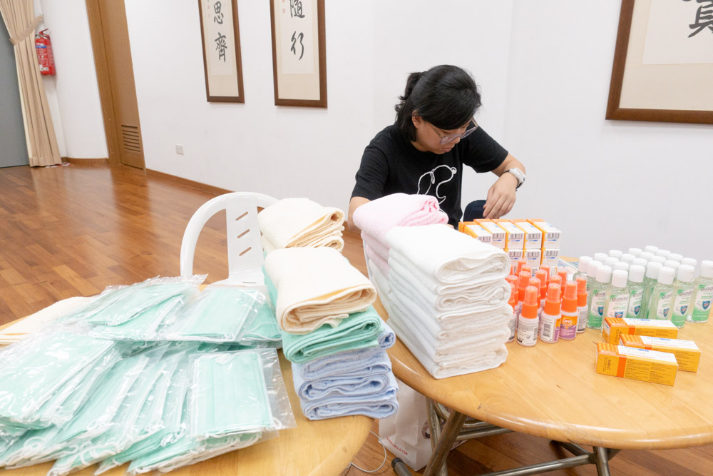 Staff from Charity Development Department, Lee Yi Xuan swiftly prepares the care packages at Jing Si Hall. (Photo by Chen Ya Yin) 